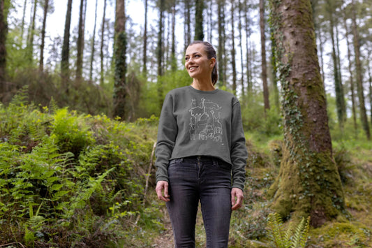 Woman in a forest wearing The Gallivanters' Colouring Club Kenya Wildlife Boxy Jumper featuring animals seen in Nairobi National Park